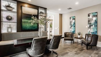 A living room with a grey sofa and a glass display cabinet